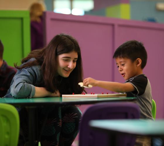 Girl working on a puzzle with a young boy