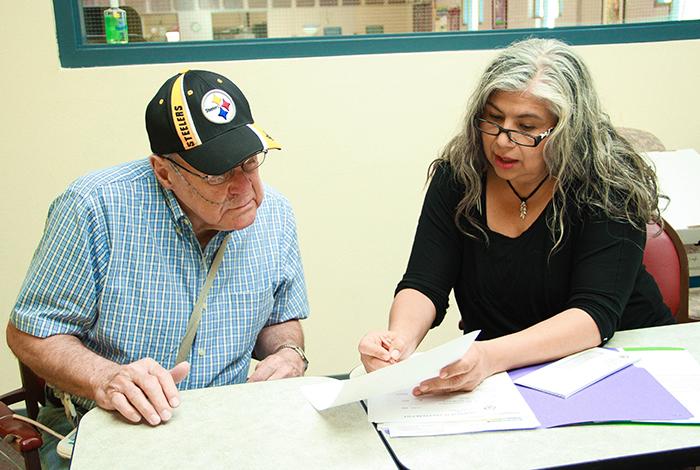 Donald Kroner fills out paperwork with SVdP staff memeber Jackie Solares.