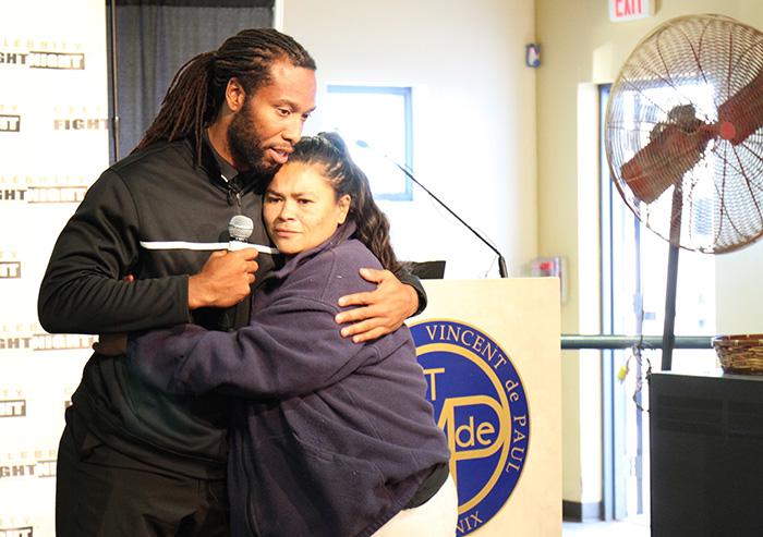 Arizona Cardinals Larry Fitzgerald hugs dining room guest.