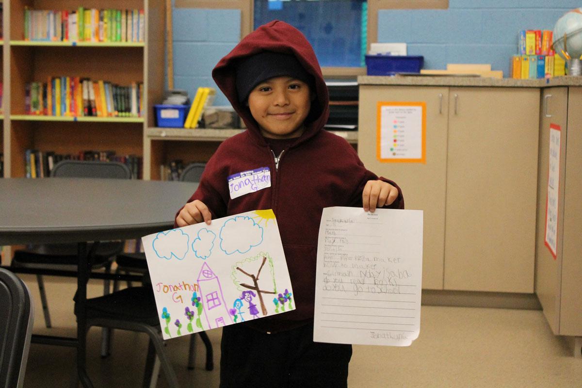 Dream Center student Jonathan, 8, holds up for display his letter and drawing to his Rwandan pen pal