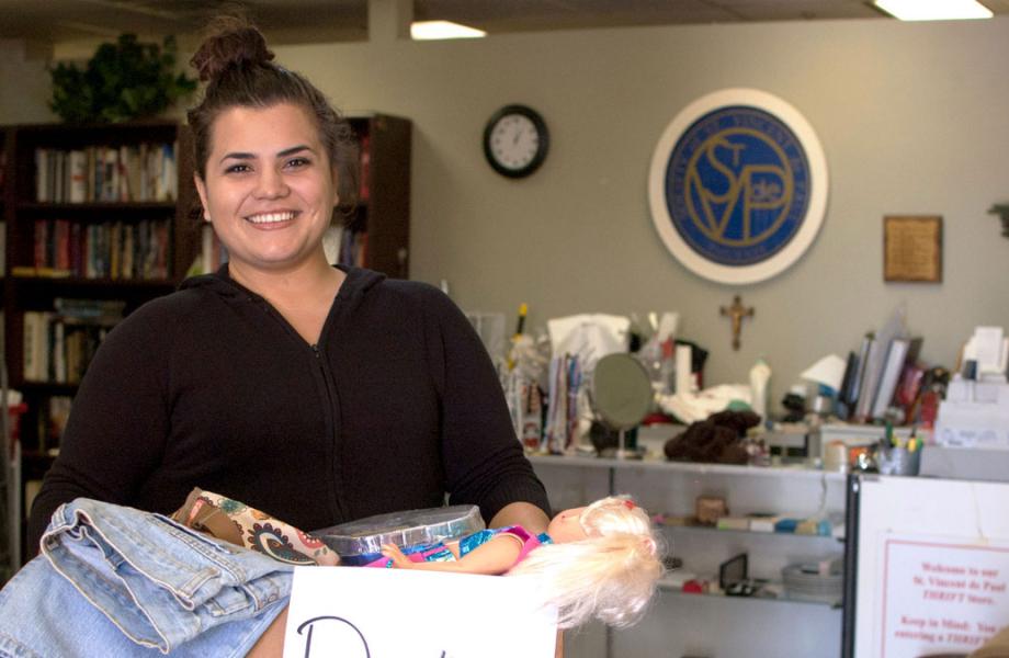 A volunteer holds a box of thrift store donations.