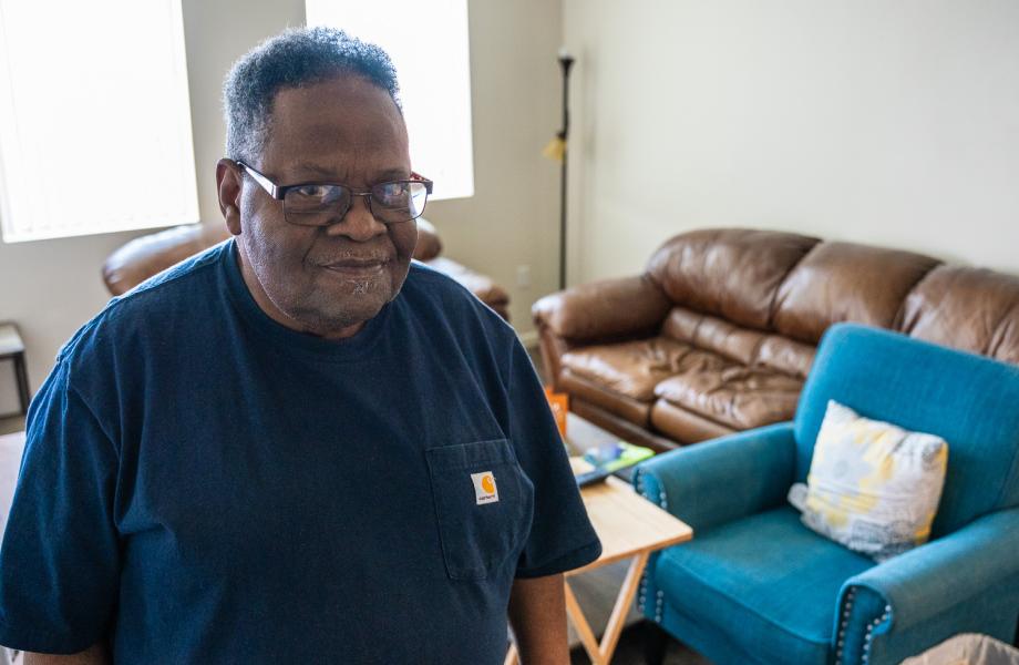 Michael Clark stands in the living room of his new apartment.