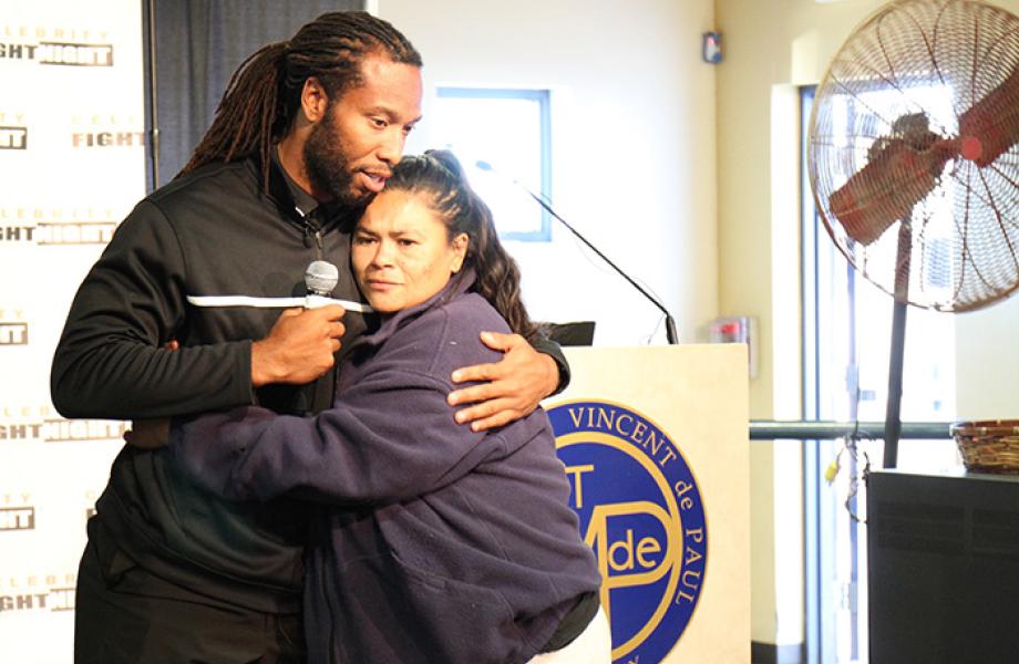 Arizona Cardinals Larry Fitzgerald hugs dining room guest.