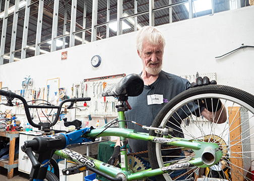 Man looking at the wheel of a bike