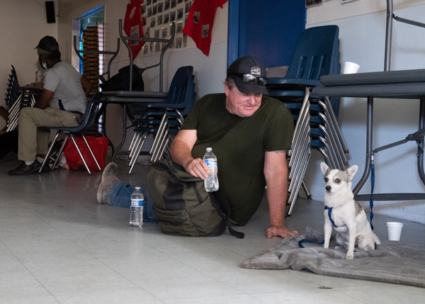 Man sitting on the ground looking at his dog