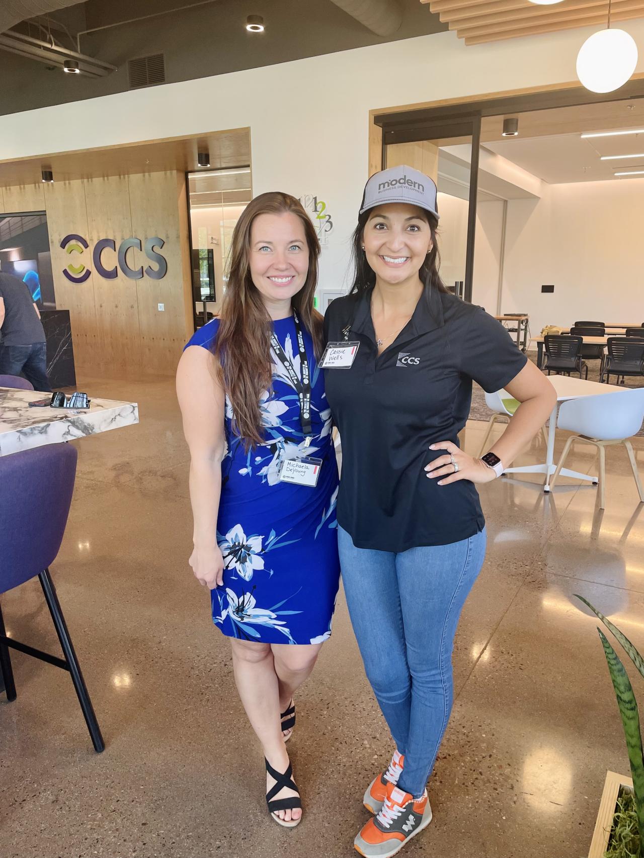 Two women posing together in business attire