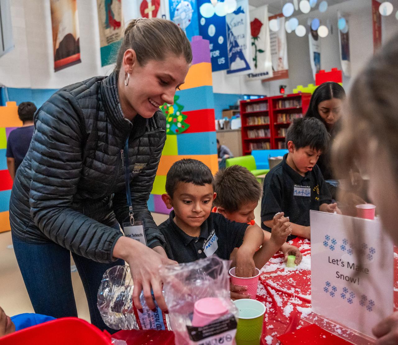 A Next Phase volunteer helps a student with a craft project.