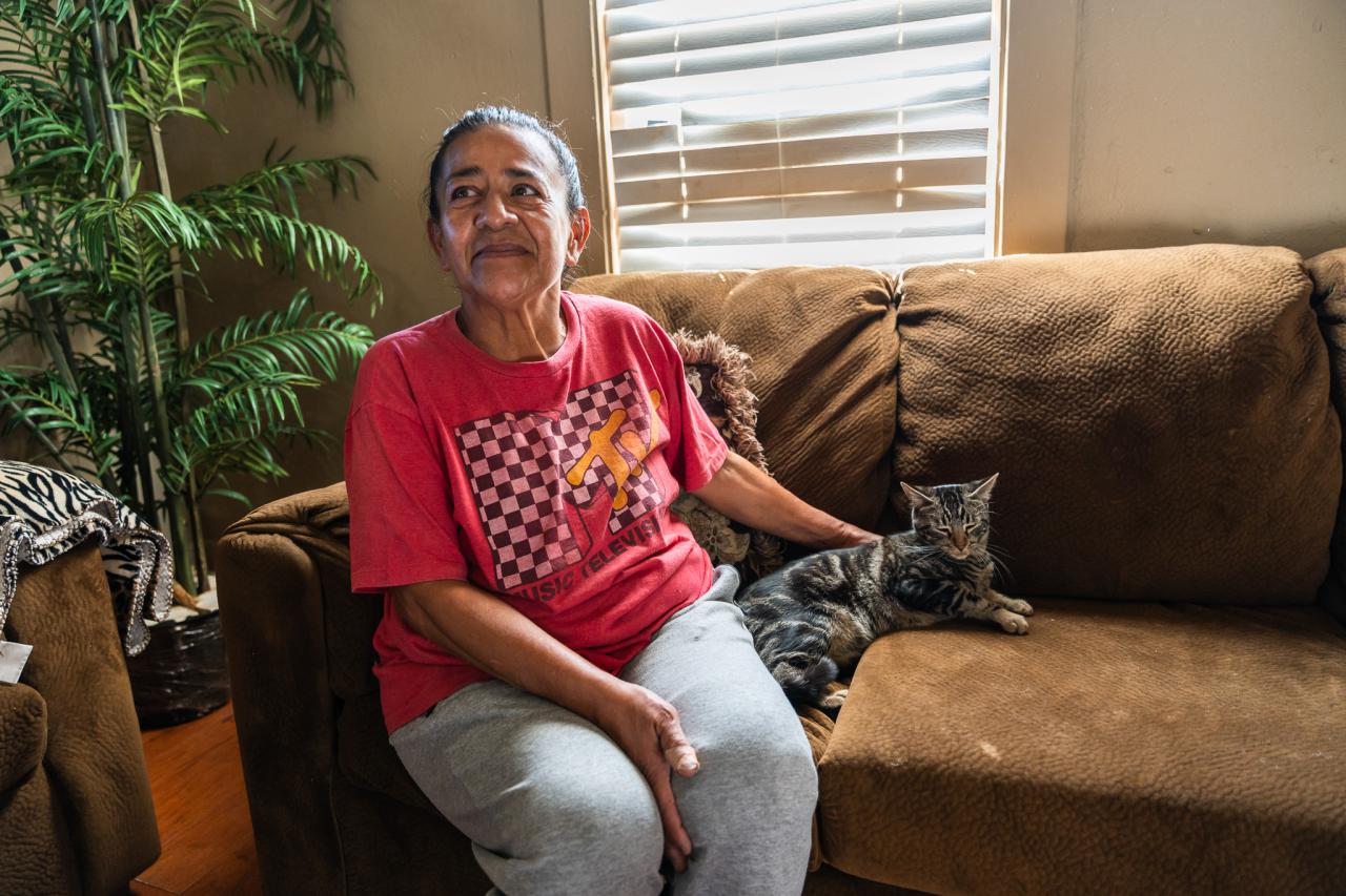 Margarita sits in her living room with her recently adopted fur friend.