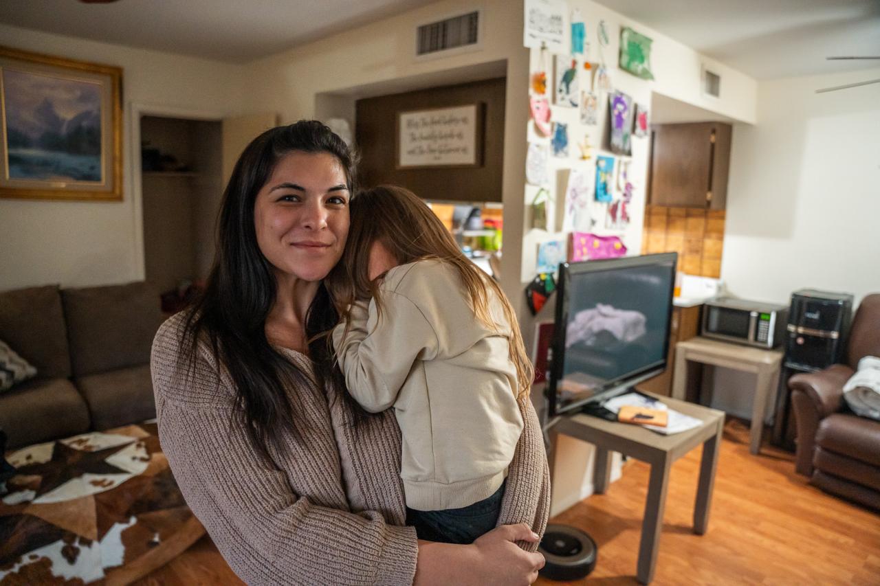 Jesse Sandau, the recipient of help from the Homelessness Prevention program, stands in her home with her daughter.