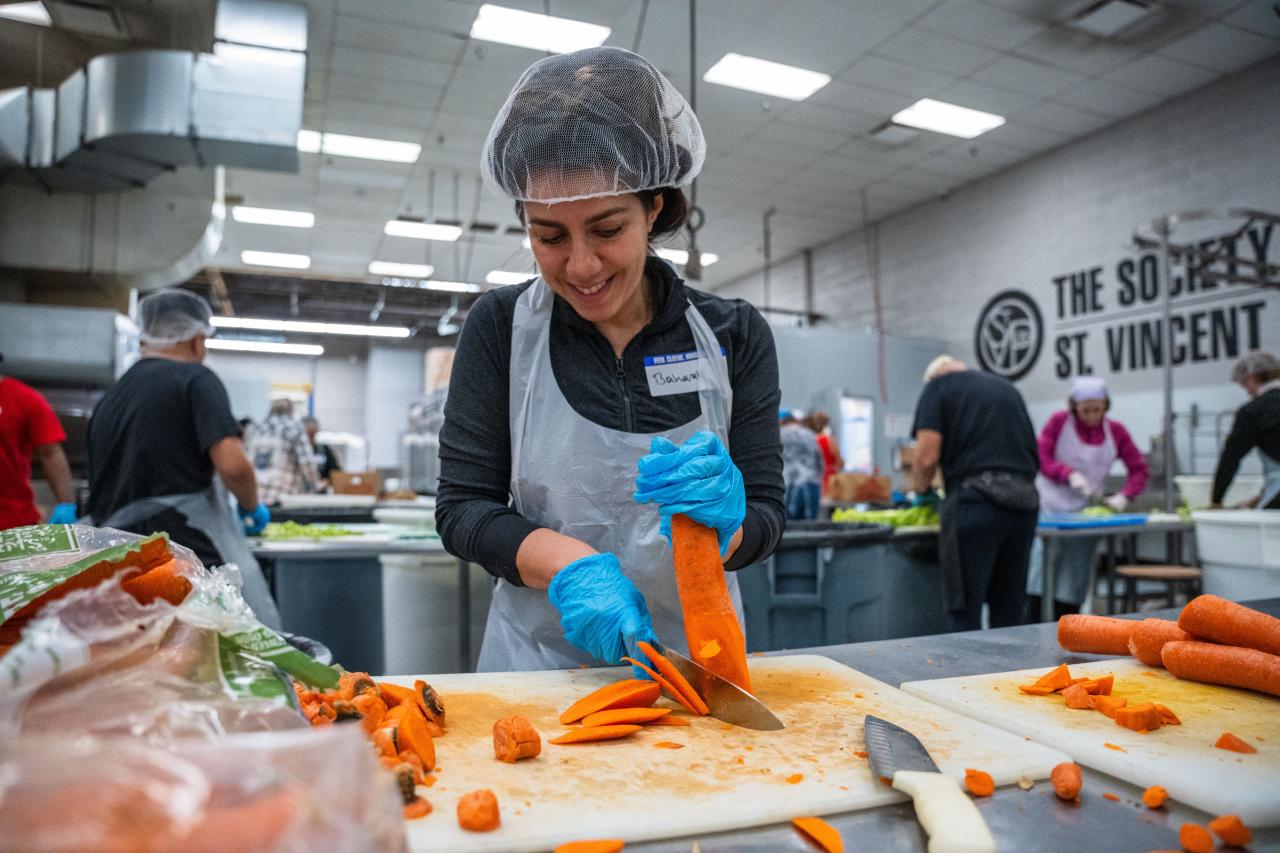 Woman cutting carrots in SVdP Kitchen