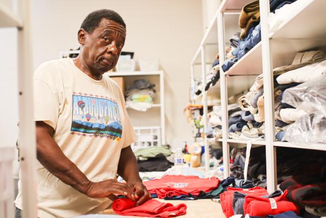 Man looking at the camera while folding clothes